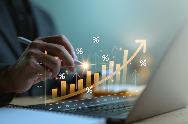 Person reviewing rising financial growth charts on a laptop screen